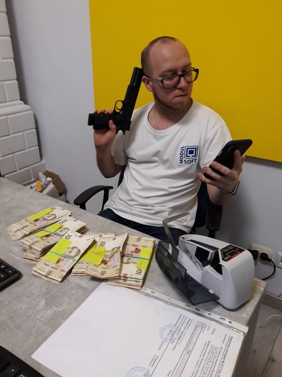 Employee with toy gun and money on table