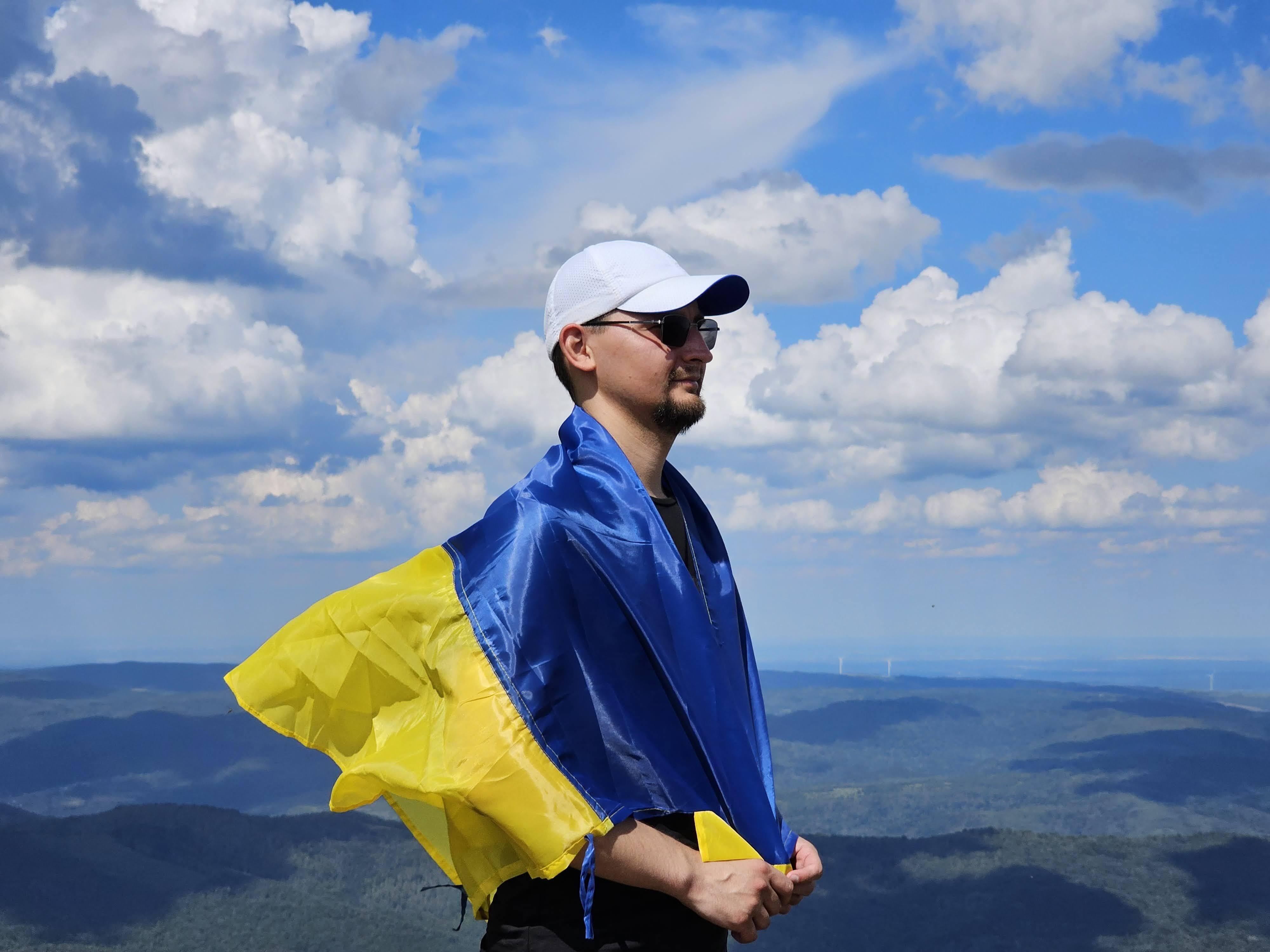 Employee on mountain top with Ukrainian flag